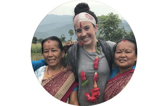 Student standing between two local women in Nepal