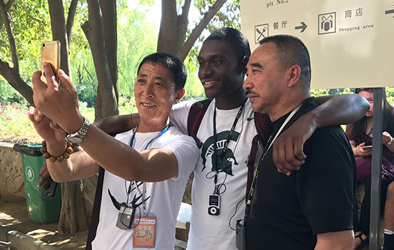 MSU student taking photo with local people in China