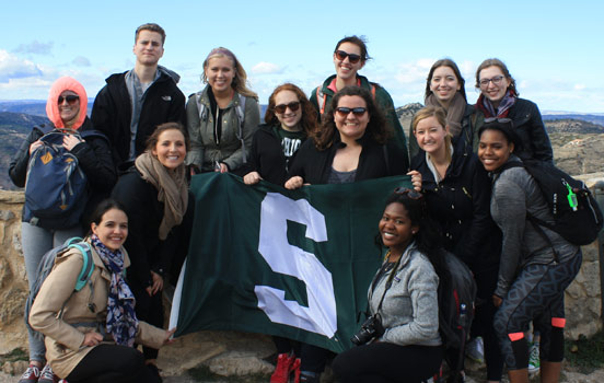 Group of students holding Spartan flag