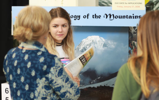 Program director talking with students at the Expo